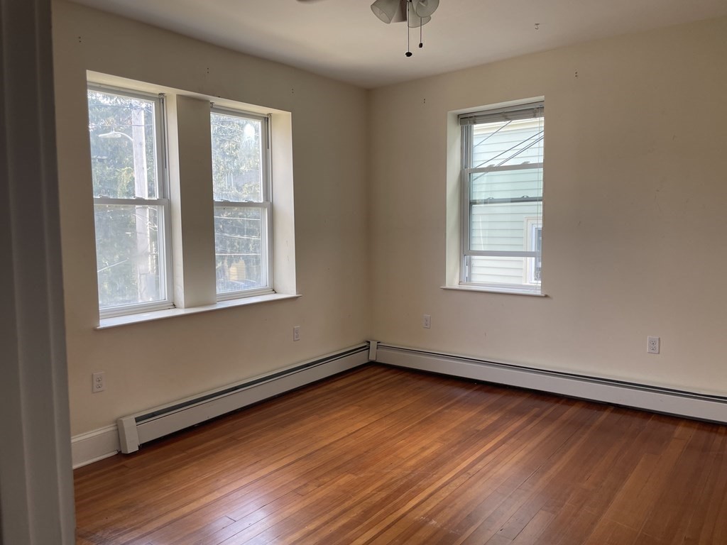 133 Fayerweather Street Cambridge, MA 02138 - Photo 15 of 27 an empty room with wooden floor and windows