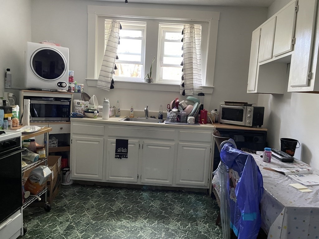 133 Fayerweather Street Cambridge, MA 02138 - Photo 17 of 27 a view of kitchen with a sink a microwave and cabinets