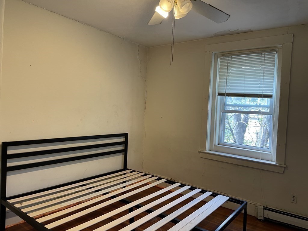 133 Fayerweather Street Cambridge, MA 02138 - Photo 21 of 27 a bedroom with a bed and a chandelier