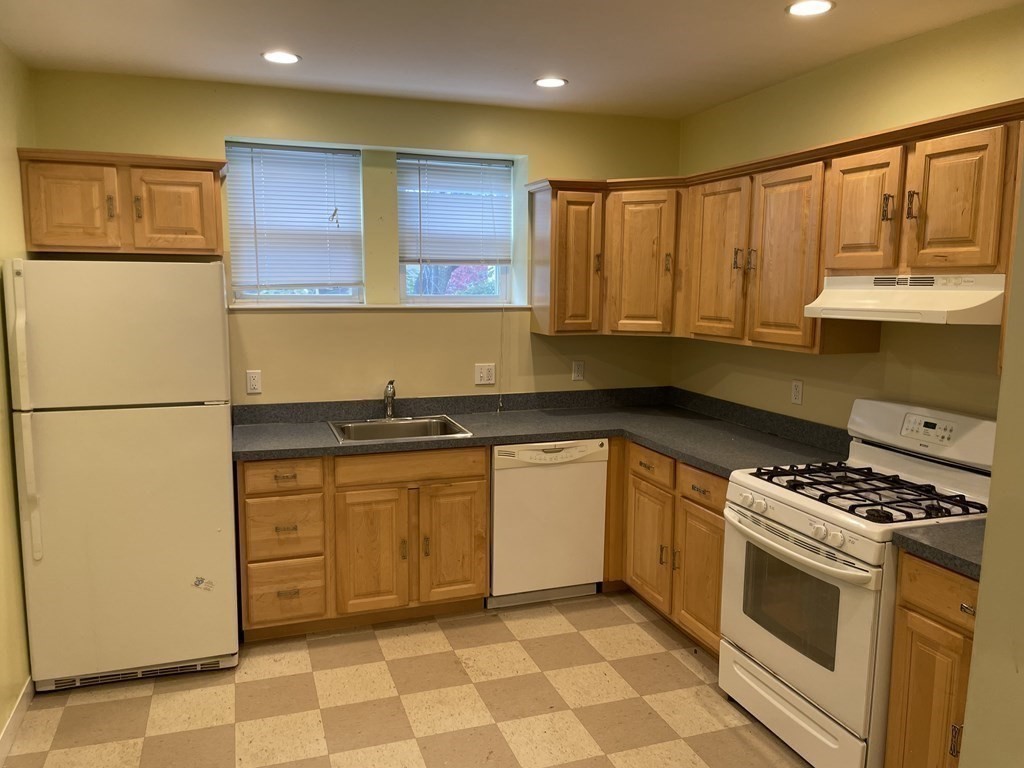 133 Fayerweather Street Cambridge, MA 02138 - Photo 6 of 27 a kitchen with stainless steel appliances granite countertop a stove a sink and a refrigerator