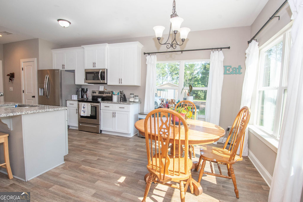 2046 Mcwilliams Barber Road Luthersville, GA 30251 - Photo 24 of 43 a view of a dining room with furniture a chandelier and wooden floor
