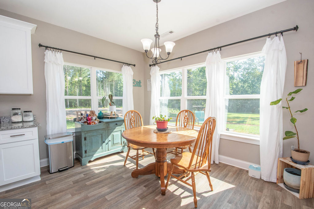 2046 Mcwilliams Barber Road Luthersville, GA 30251 - Photo 25 of 43 a dining room with wooden floor a chandelier a glass table and chairs