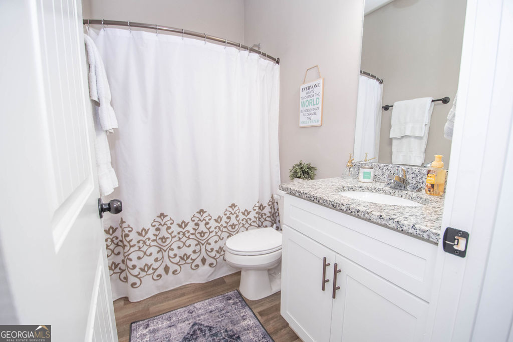 2046 Mcwilliams Barber Road Luthersville, GA 30251 - Photo 38 of 43 a bathroom with a granite countertop sink a toilet and a mirror