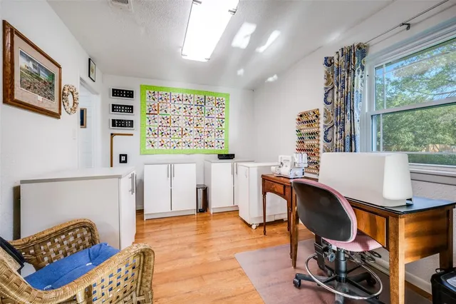 a view of a workspace with furniture and a window