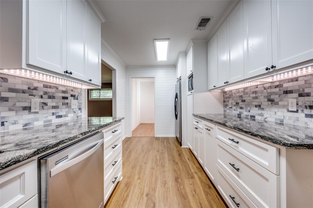 1027 Stanley Street Denton, TX 76201 - Photo 15 of 38 a spacious white kitchen with granite countertop a stove and a sink