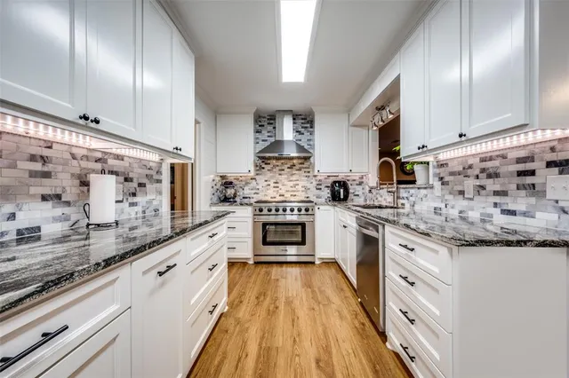 a kitchen with stainless steel appliances granite countertop a stove and cabinets