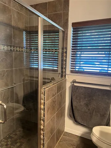 a bathroom with a toilet and a shower