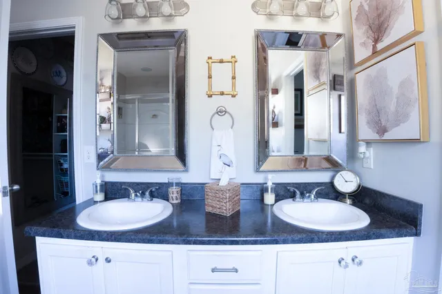 a bathroom with double vanity sinks and a mirror