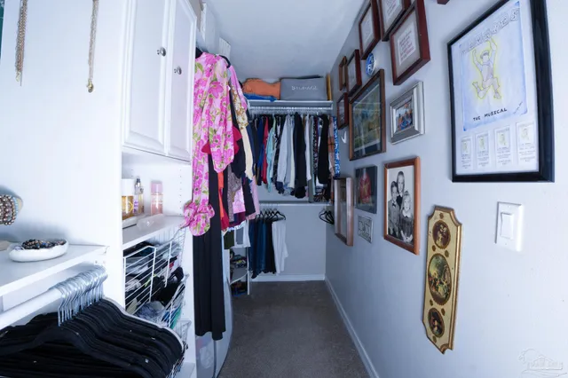 a view of walk in closet with clothes and shoes