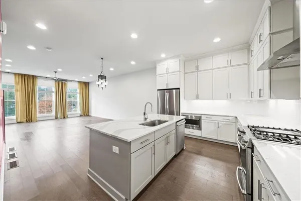 a kitchen with granite countertop a sink stove and cabinets