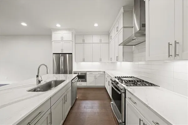 a kitchen with stainless steel appliances granite countertop a sink a refrigerator and a stove