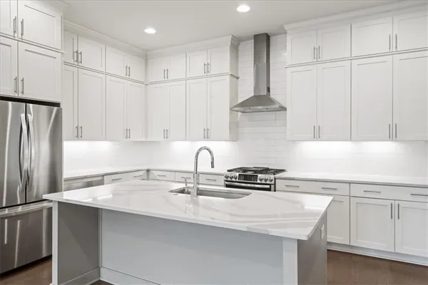 a kitchen with kitchen island a white cabinets and refrigerator