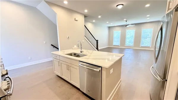 a kitchen with a sink a refrigerator and wooden floor