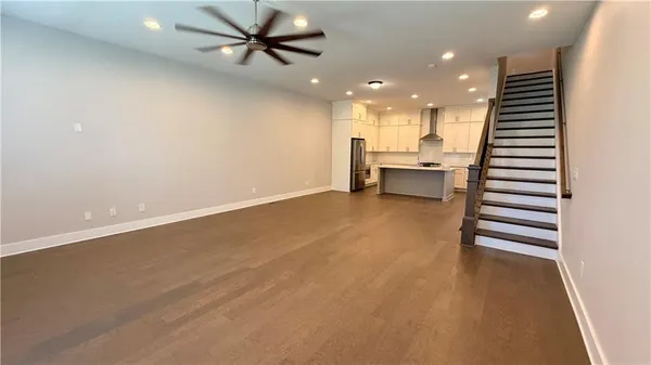 a big room with kitchen island white cabinets and stainless steel appliances
