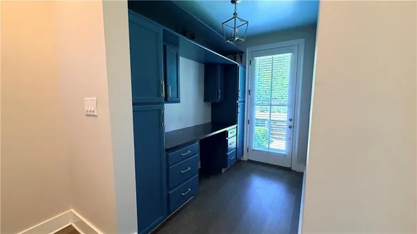 a view of a hallway with wooden floor and cabinet