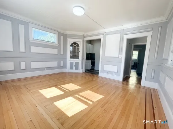 a view of empty room with wooden floor and windows