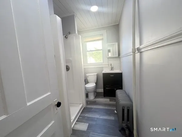 a bathroom with a sink a toilet and shower