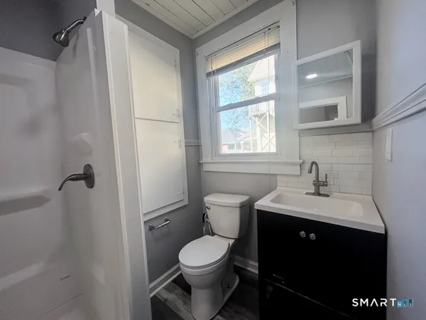 a bathroom with a sink a toilet and shower