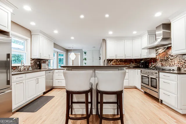 a kitchen with white cabinets and appliances