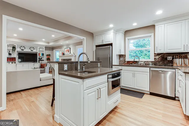a kitchen with stainless steel appliances granite countertop a sink stove and refrigerator