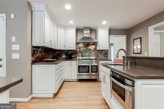 a kitchen with stainless steel appliances granite countertop a stove sink and cabinets