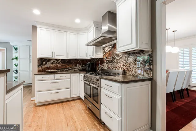 a kitchen with granite countertop white cabinets and white appliances