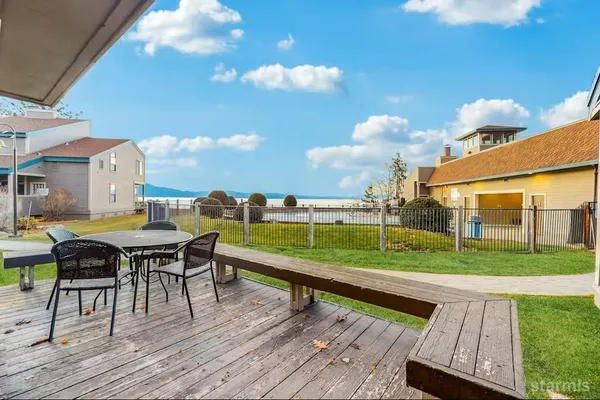 a view of a deck with table and chairs with wooden floor and fence