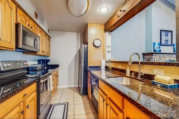 a kitchen with stainless steel appliances granite countertop a sink and a stove