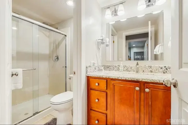 a bathroom with a granite countertop sink toilet and shower
