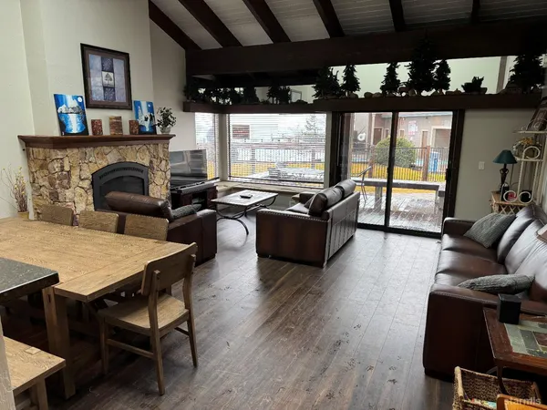 a living room with furniture a flat screen tv and a floor to ceiling window
