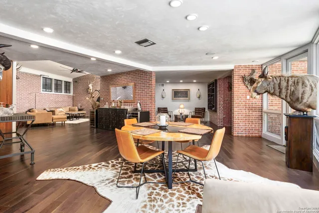 a living room with furniture a wooden floor and a large window
