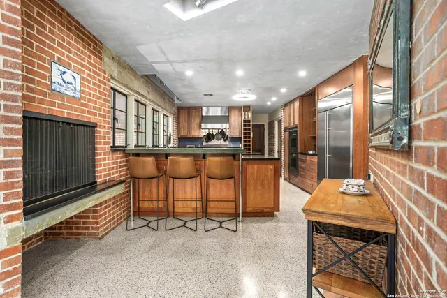 a kitchen with a table chairs refrigerator and cabinets