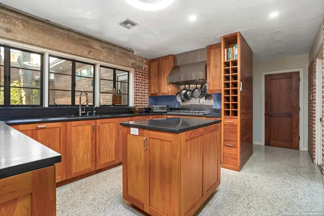 a kitchen with stainless steel appliances granite countertop a sink and a refrigerator