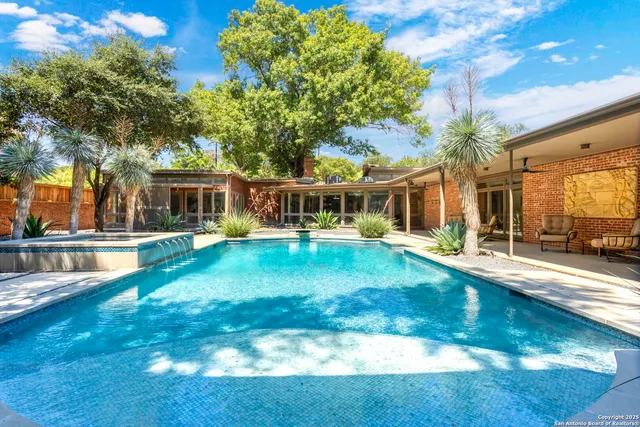 a view of a house with pool and sitting area