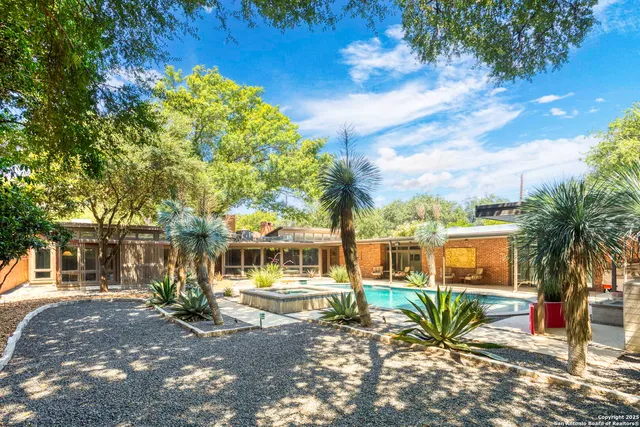 a front view of a house with a tree