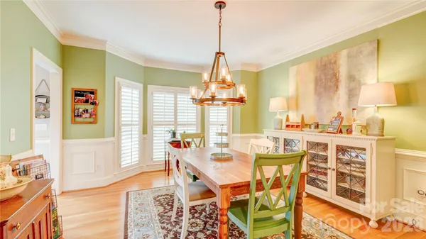 a dining room with furniture a chandelier and wooden floor