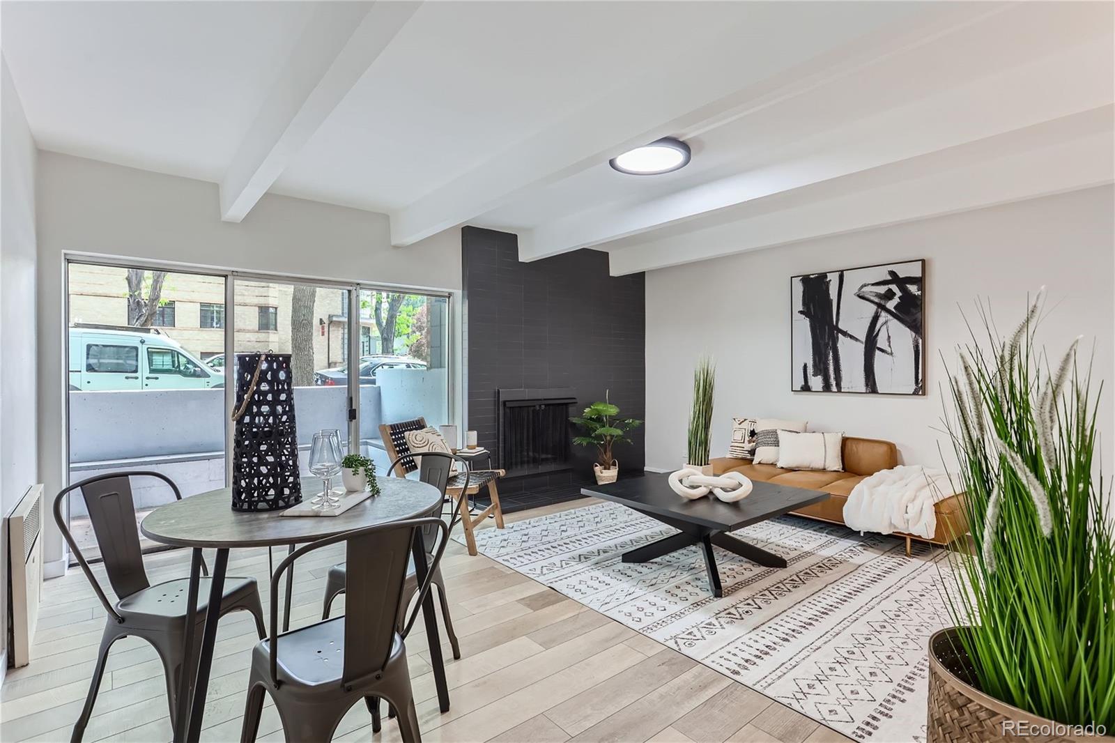 a living room with furniture potted plant and a large window