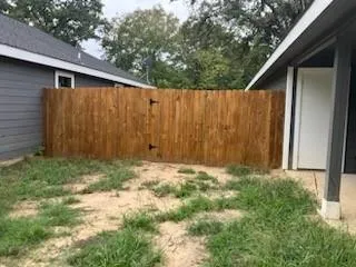 a backyard of a house with lots of green space and wooden fence