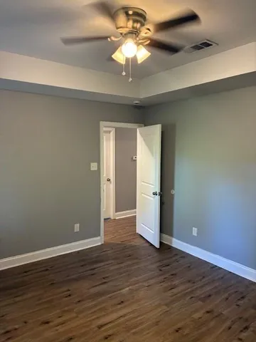 a view of an empty room with wooden floor