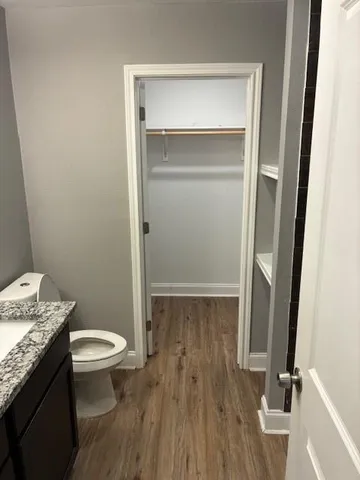 a bathroom with a granite countertop toilet and a sink
