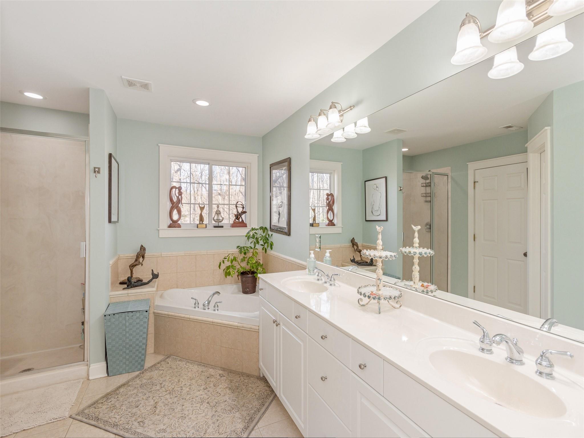 73 Cave Lane Arden, NC 28704 - Photo 28 of 45 a bathroom with a double vanity sink a mirror and a bathtub