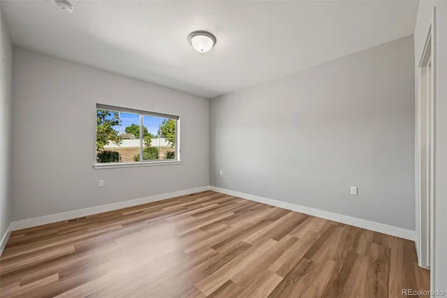 a view of empty room with wooden floor