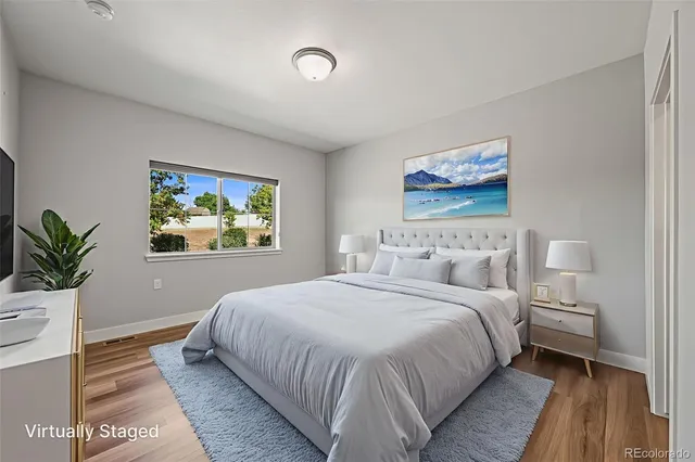 a bedroom with bed and wall painting with wooden floor