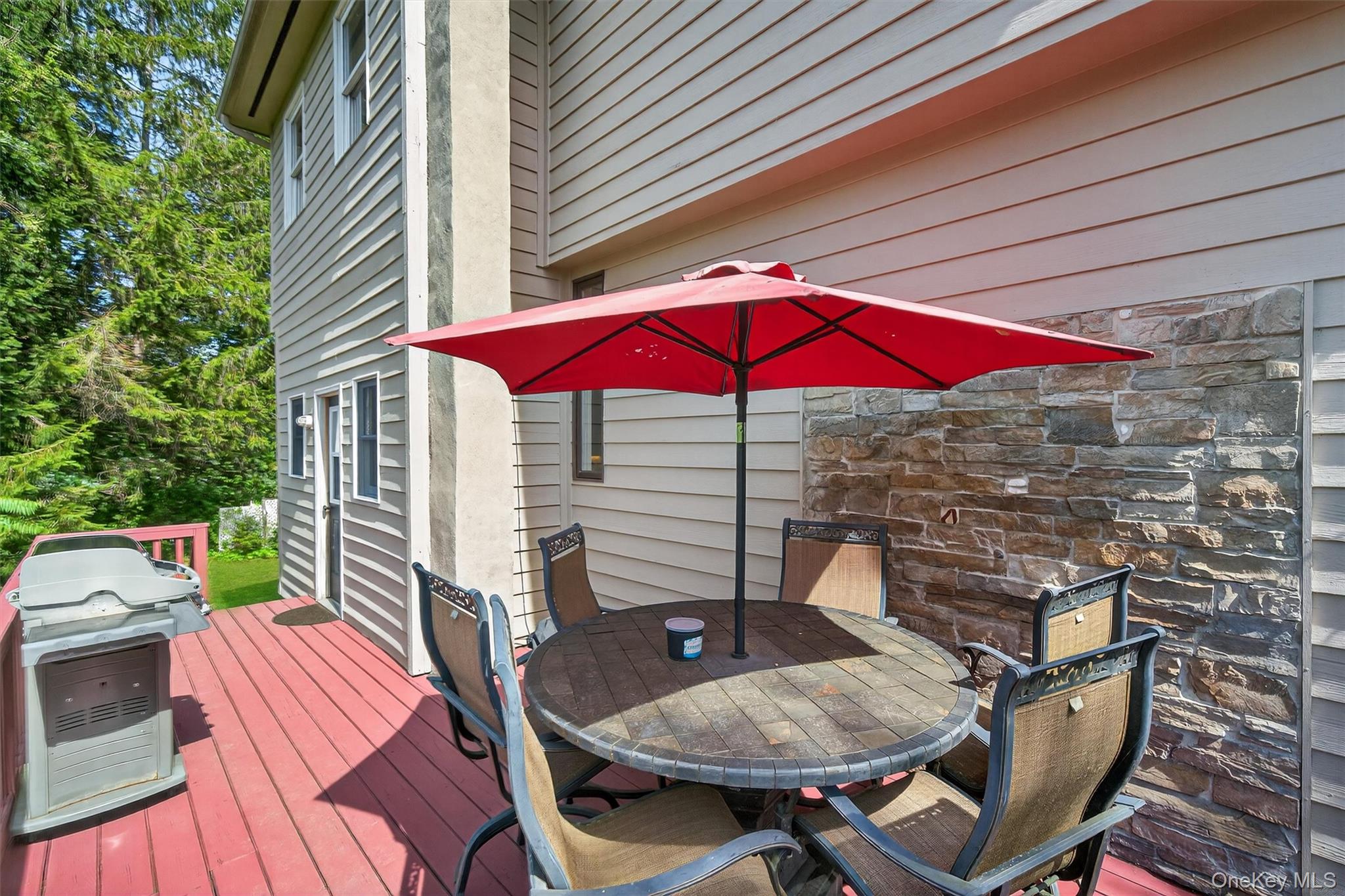 321 Bellvale Lakes Road Warwick, NY 10990 - Photo 26 of 33 a patio with a table and chairs under an umbrella