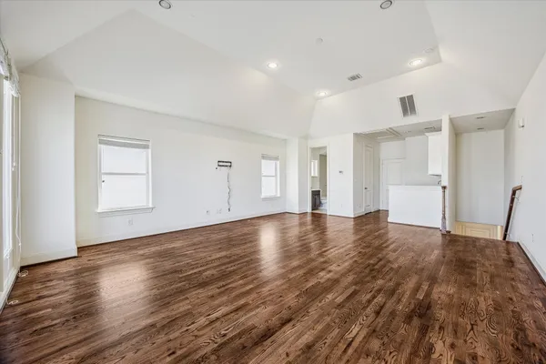 a view of empty room with wooden floor and window