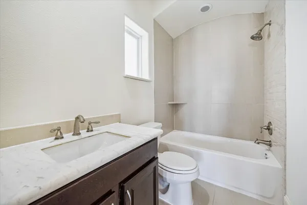 a bathroom with a granite countertop sink toilet a mirror and bathtub