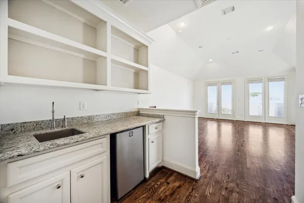 a kitchen with stainless steel appliances granite countertop a sink and cabinets with wooden floor