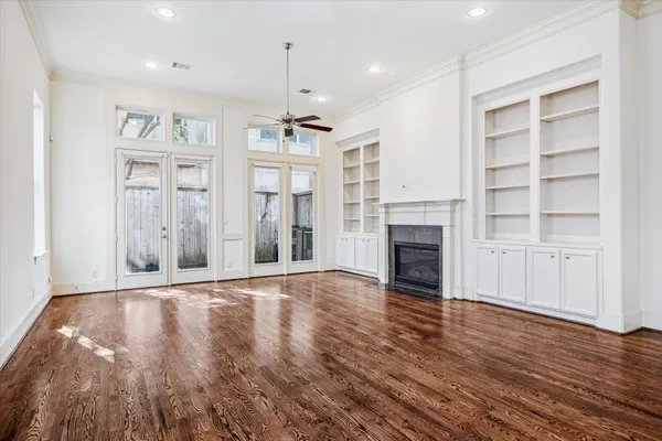 a view of a big room with wooden floor fireplace and windows