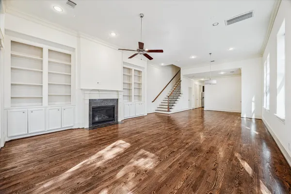wooden floor in an empty room with a fireplace and a window