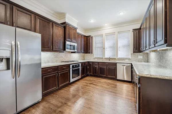 a kitchen with stainless steel appliances granite countertop a stove a sink dishwasher a refrigerator and a microwave oven